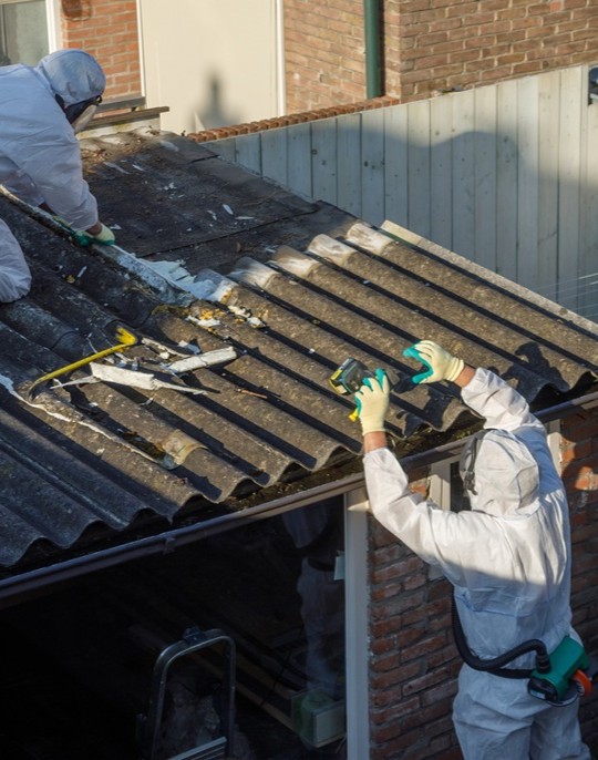 Techniciens protégés retirant des plaques amiantées sur une toiture